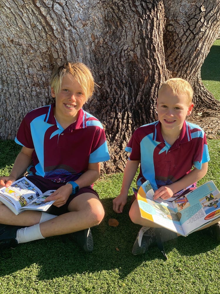 A Year 6 student reading with his Kinder buddy